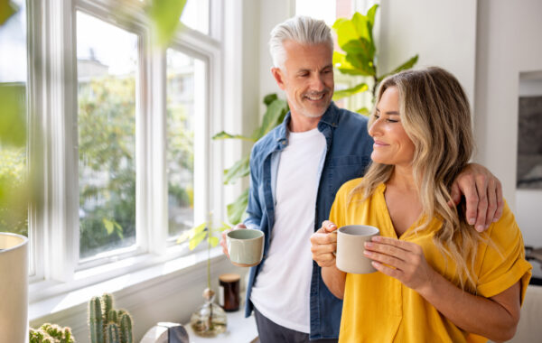 Happy couple at home drinking a cup of coffee